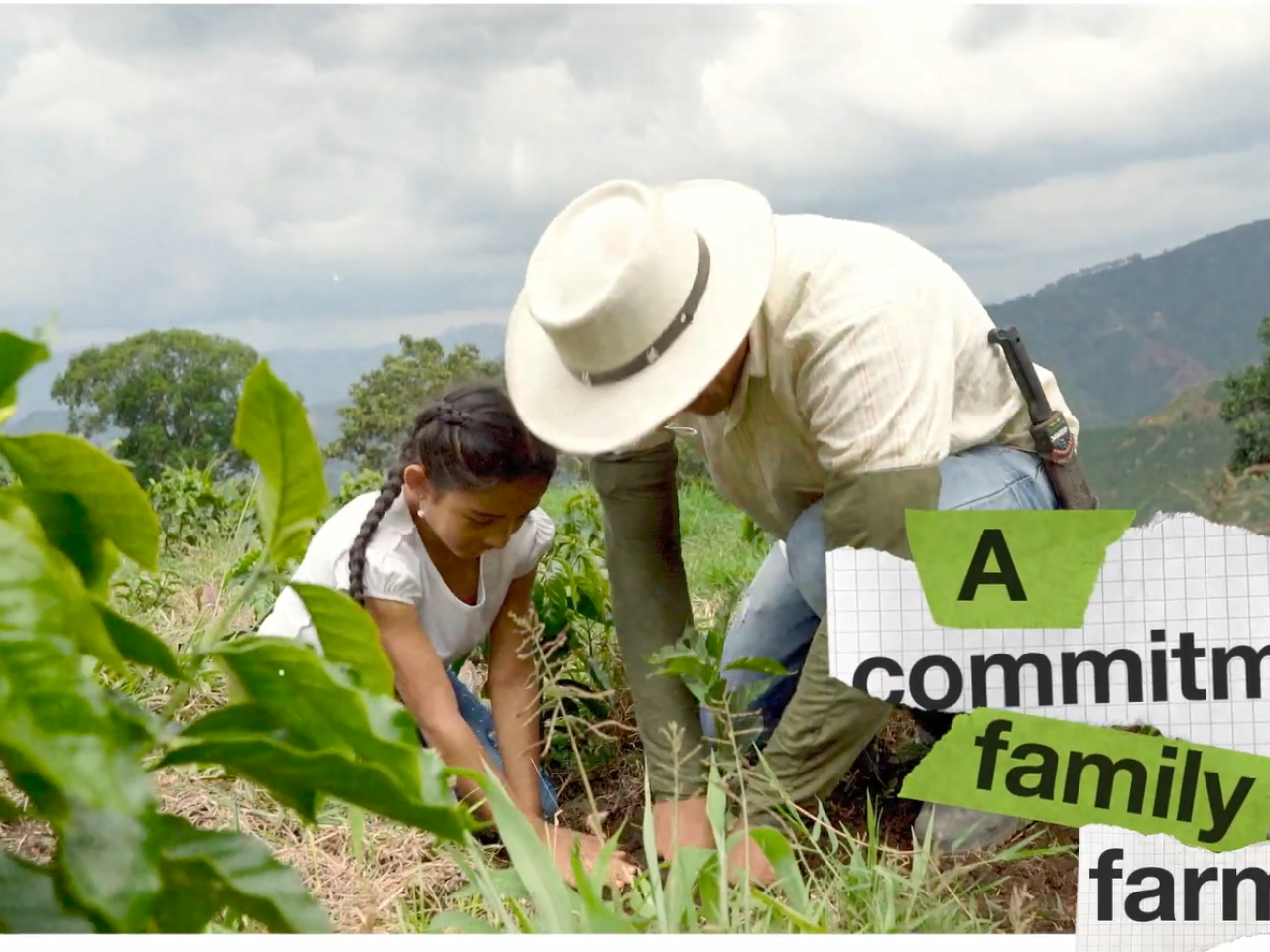 An adult and child planting in a field.