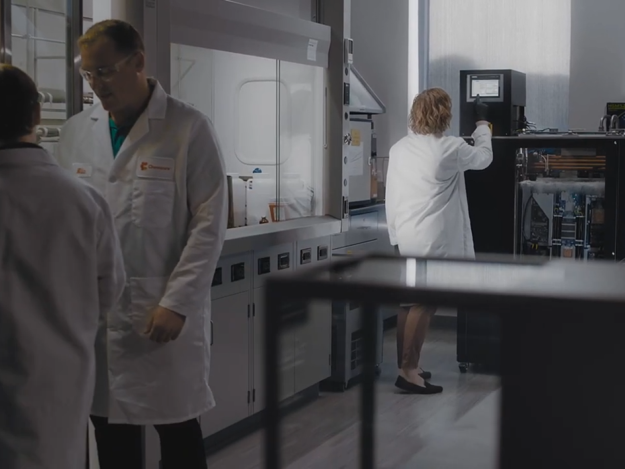 People wearing white lab coats inside a data center