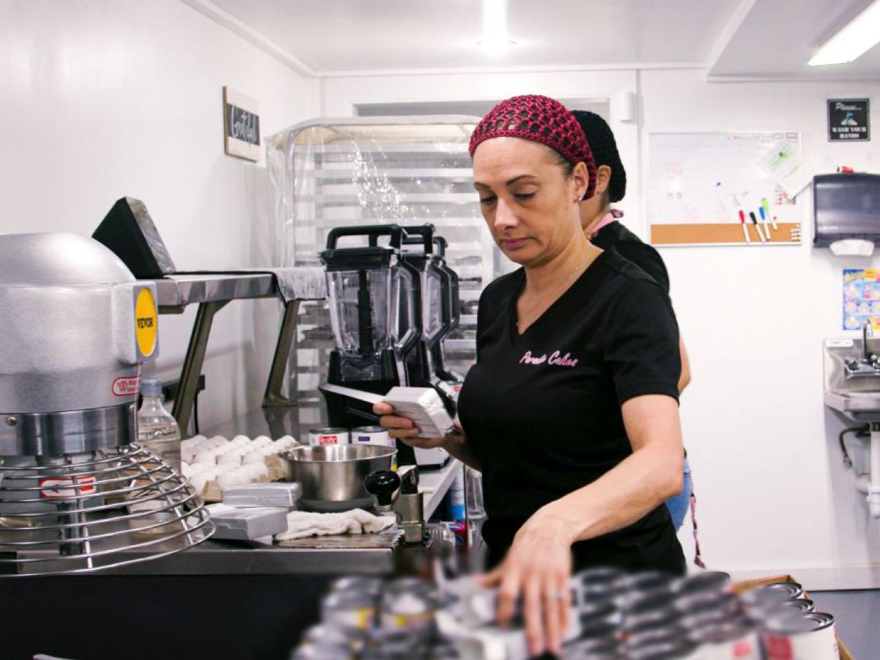 A person grabbing ingredients in a bakery setting.