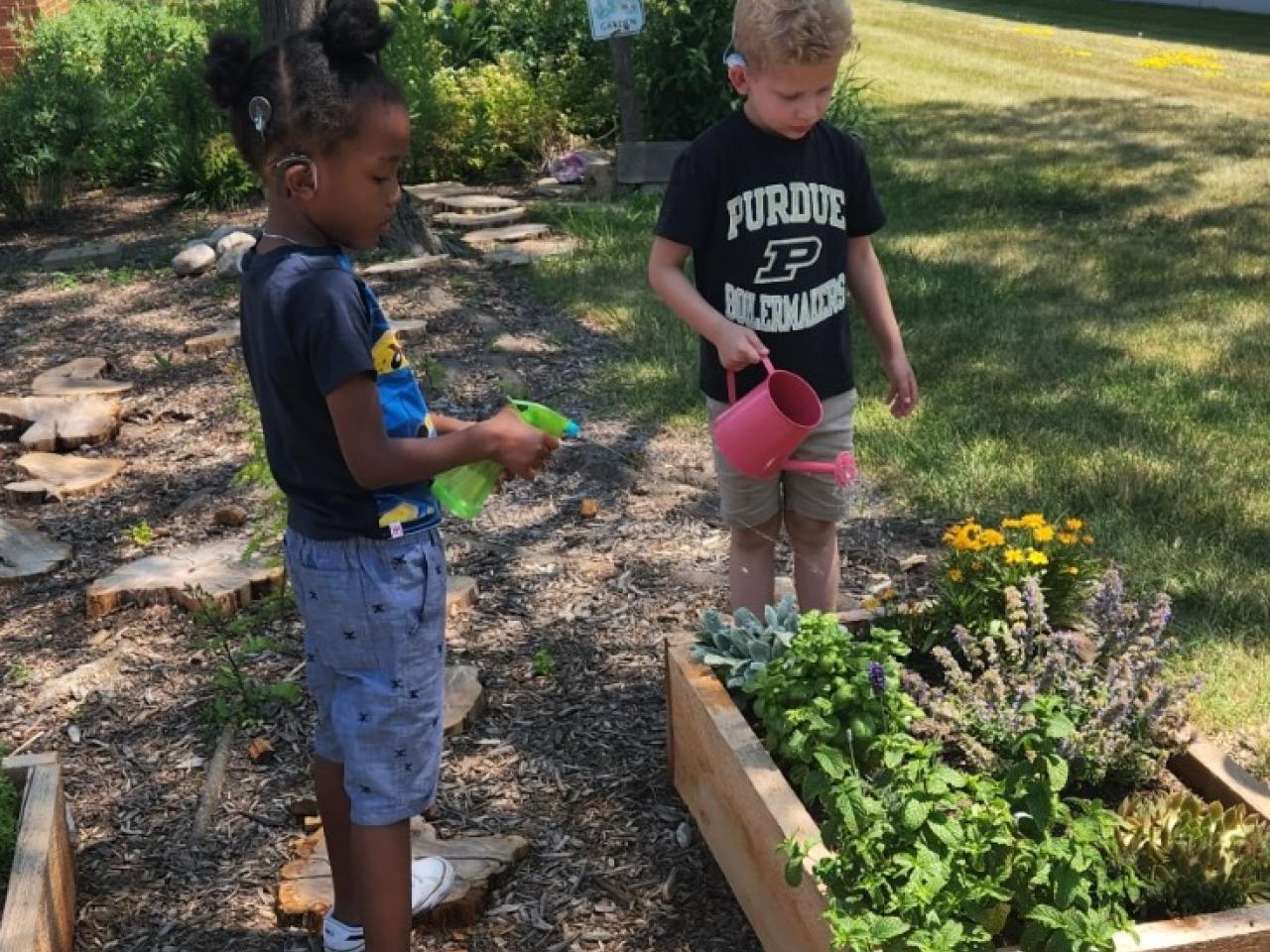 Kids watering a garden