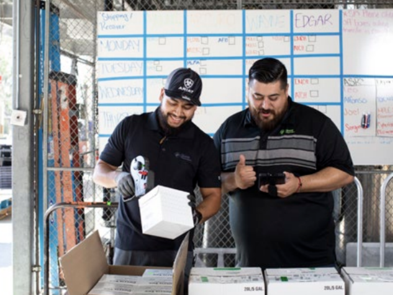 Two workers scanning products out of boxes