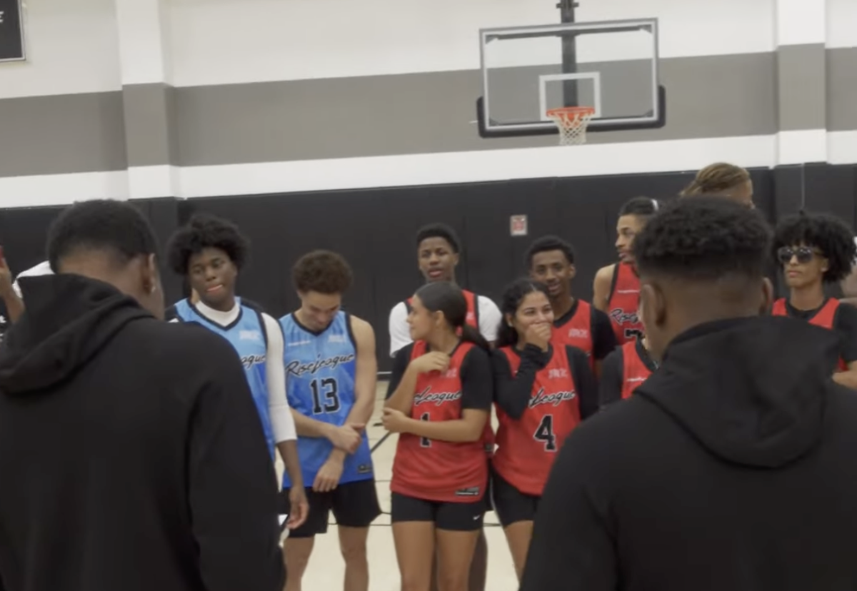 Two people reading a note to a basketball team 