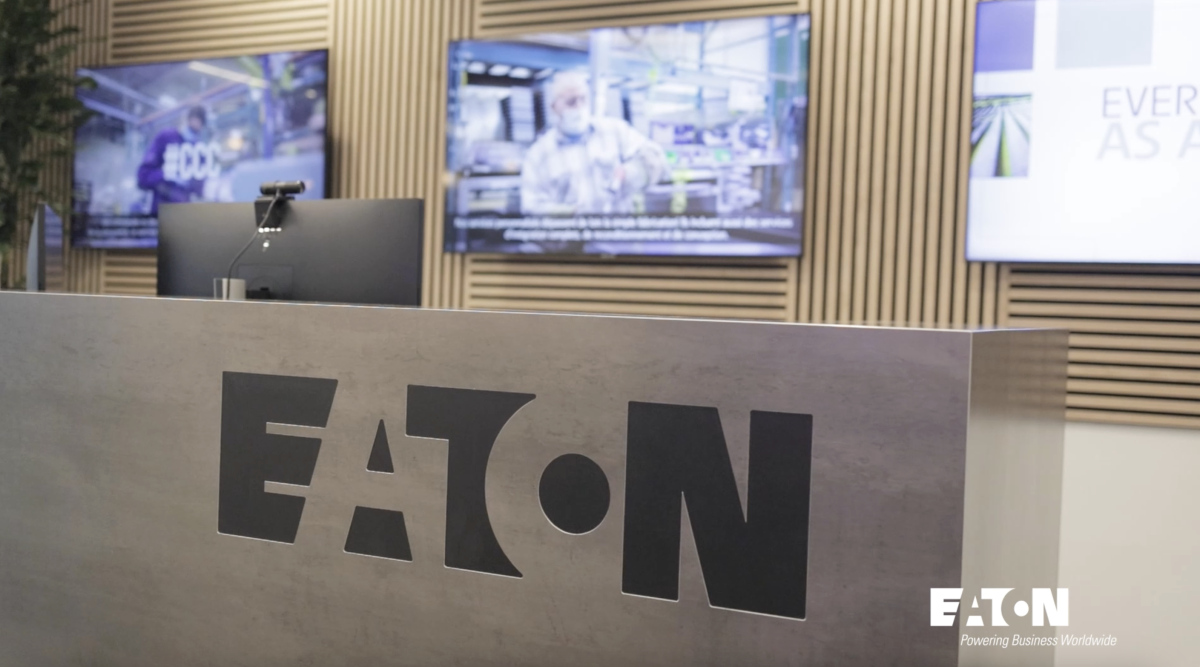 Large reception desk with the name "EATON" printed on it. Behind are several screens