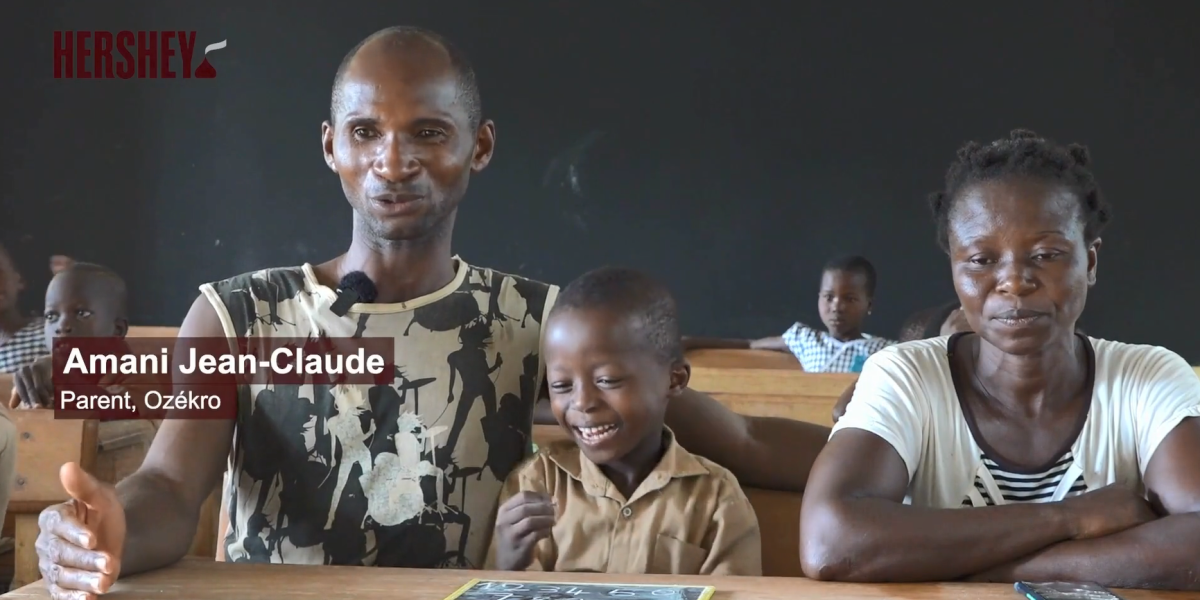 Two adults sitting with a child in a classroom.