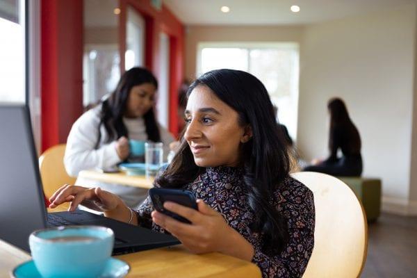 Woman sitting in cafe working on laptop 