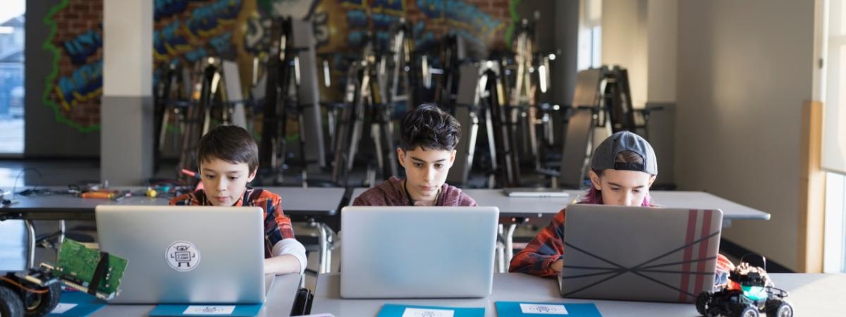 3 kids using laptops