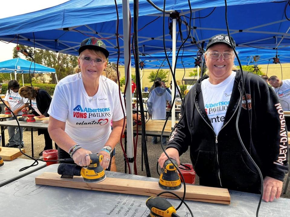 People sanding wood planks