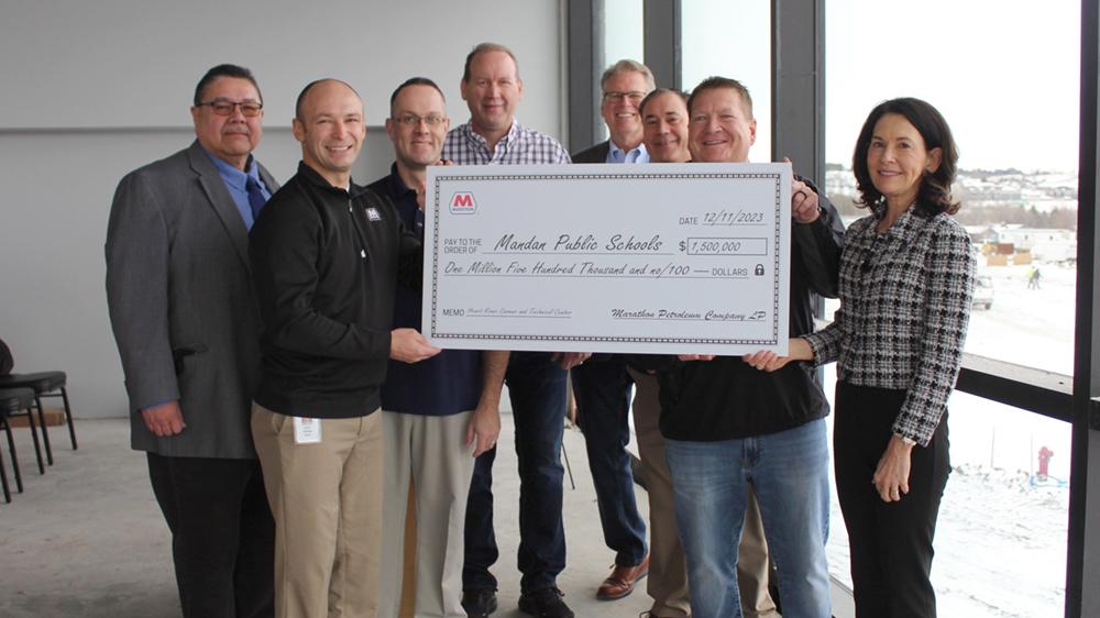 People standing, holding an oversized check