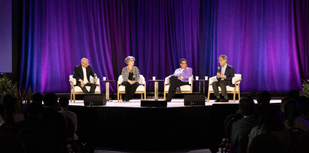 People sat on stage in front of an audience at the 2024 WELL Conference