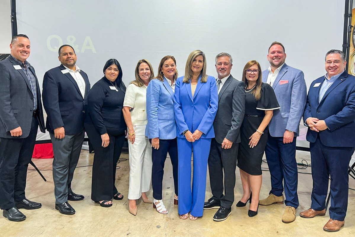 A standing group of people smiling