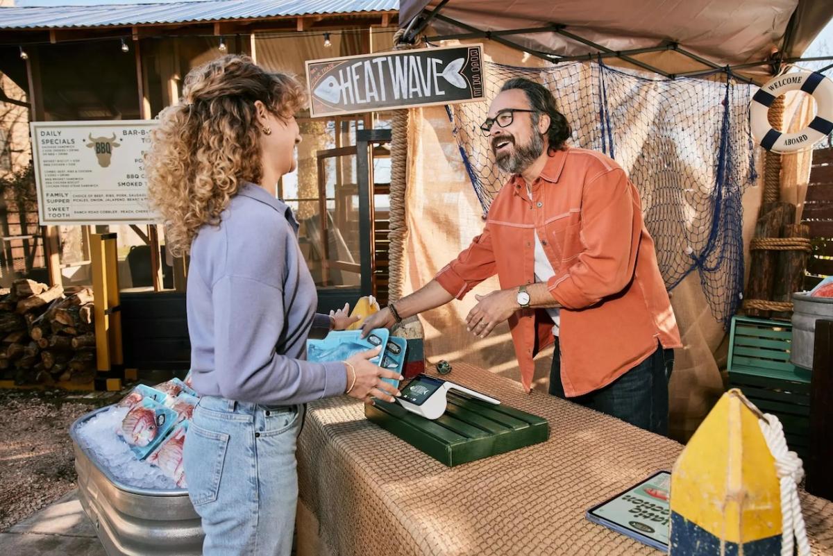 Client speaking with a business owner at a booth.