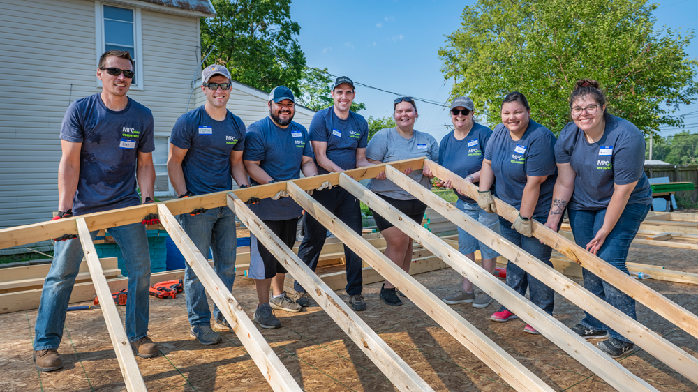 People raising a wall frame together