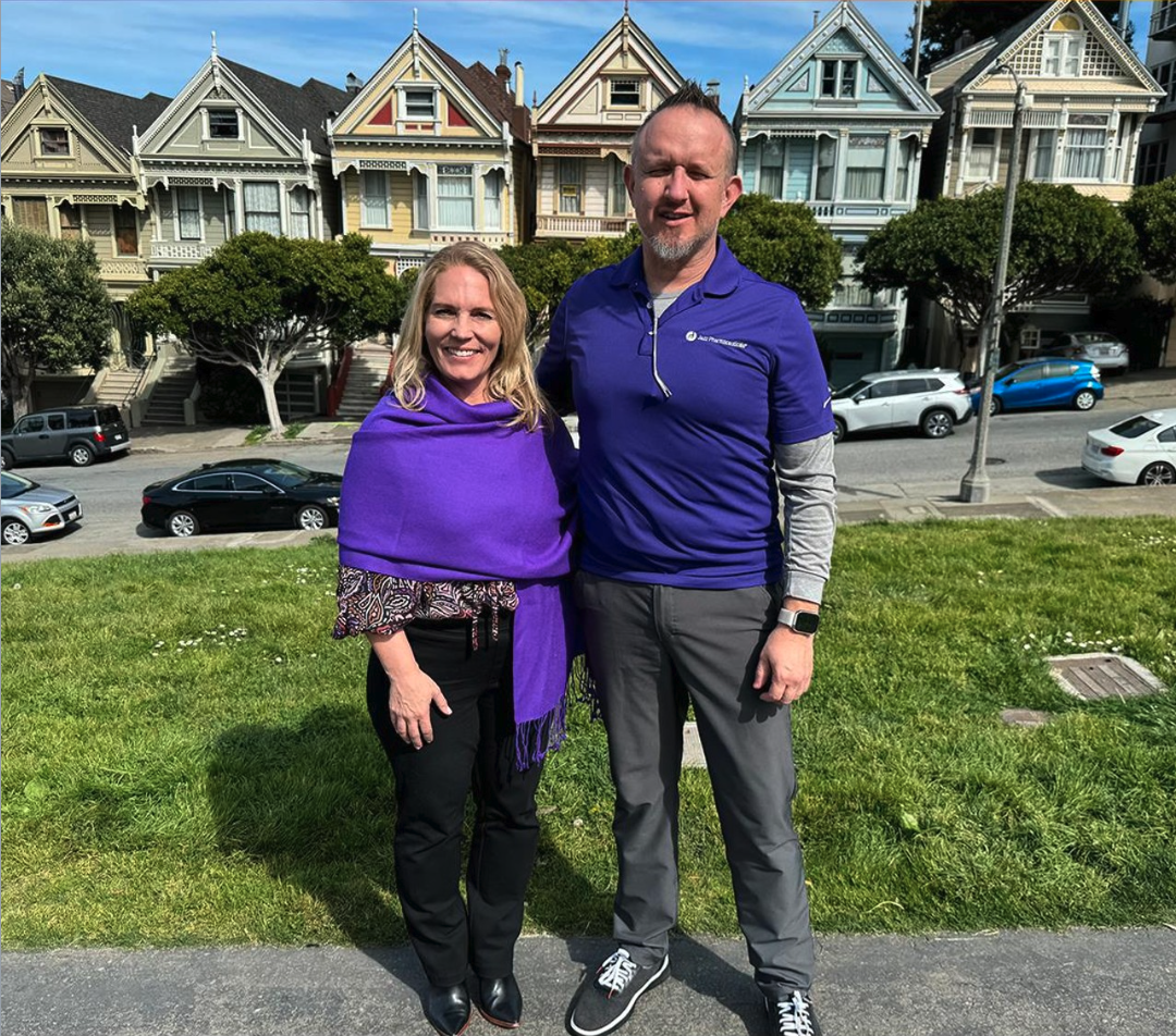 Two people standing outside wearing purple