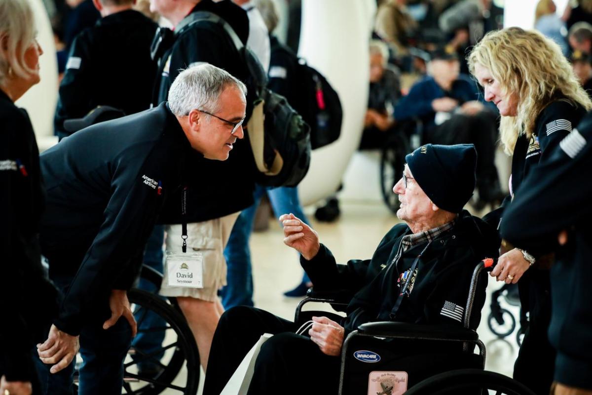 A person talking to a veteran in a wheelchair