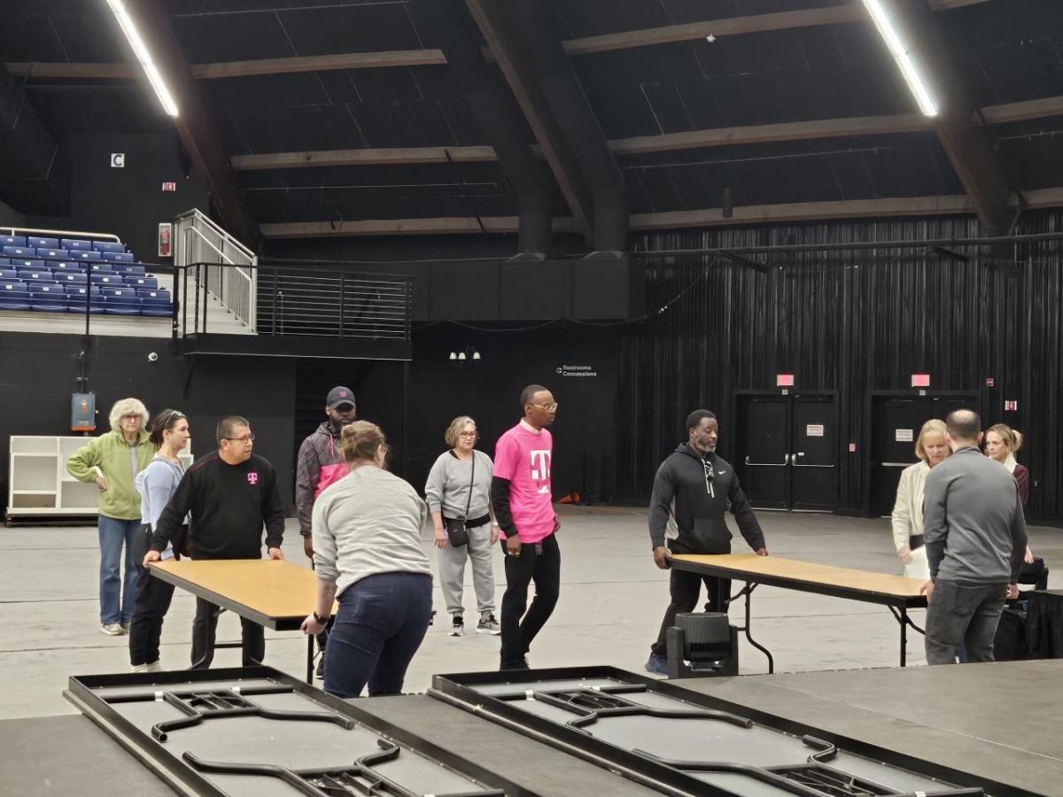 People carrying tables in an auditorium