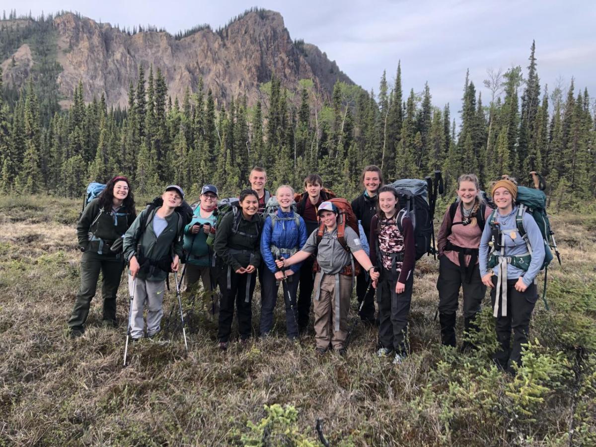 People with backpacks standing together in the wilderness