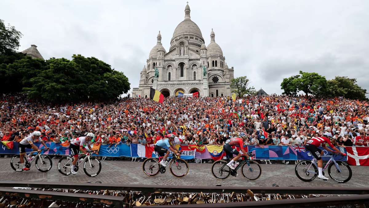 Olympic cyclists with a large crowd behind them