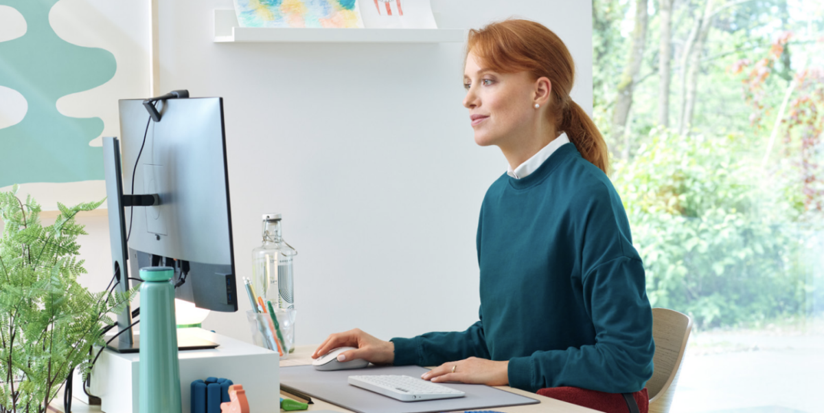 A person sat at a computer desk looking at a monitor screen