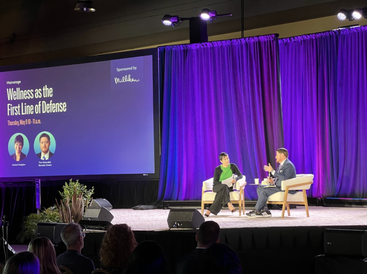 Two people sat on stage talking at the 2024 WELL Conference