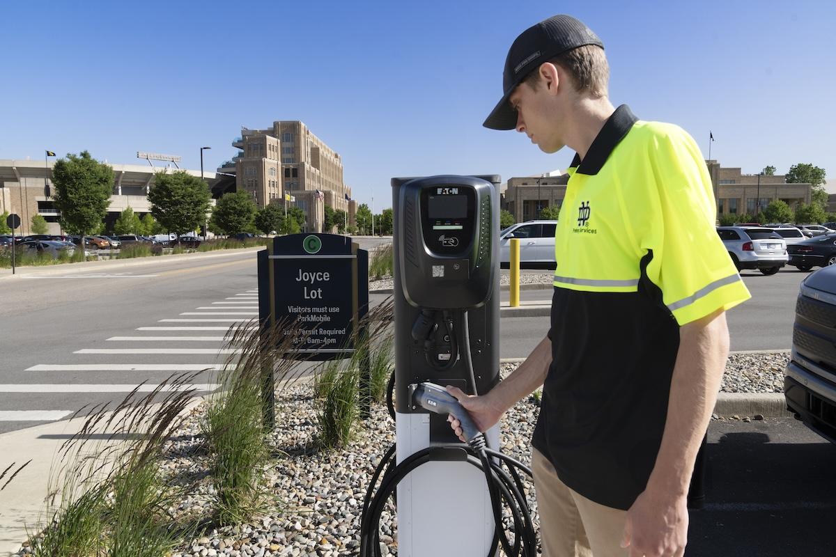 person with electric car charging station