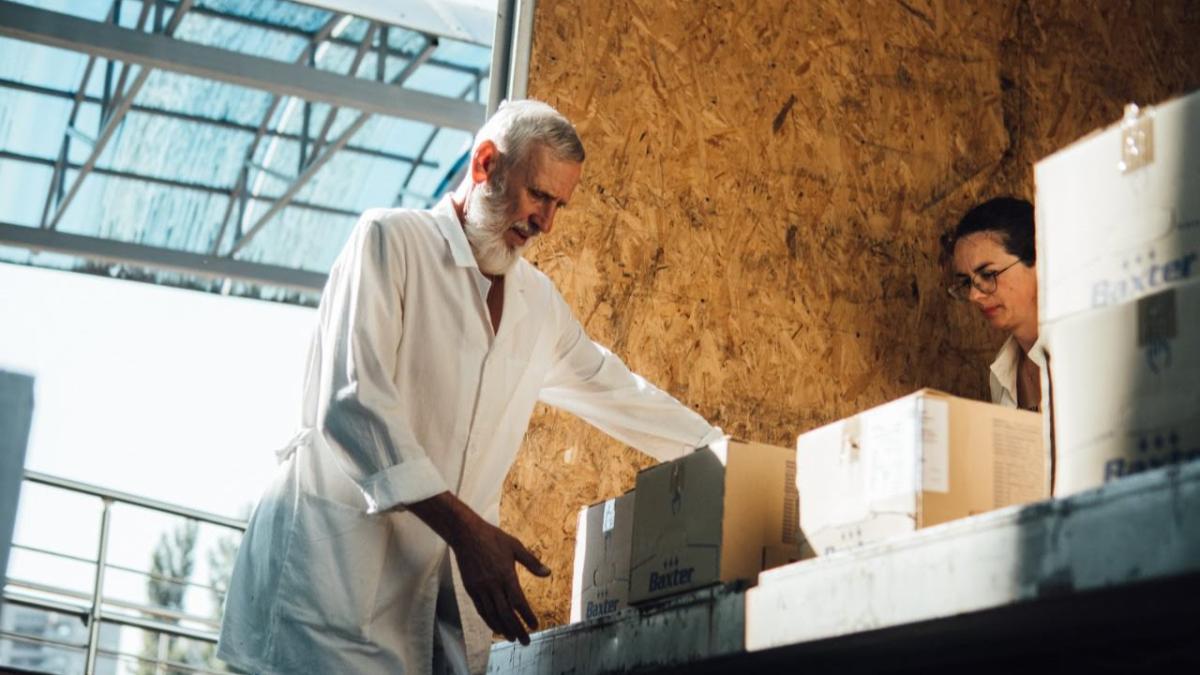 Person in Ukraine unloads boxes of IV fluids from a truck.