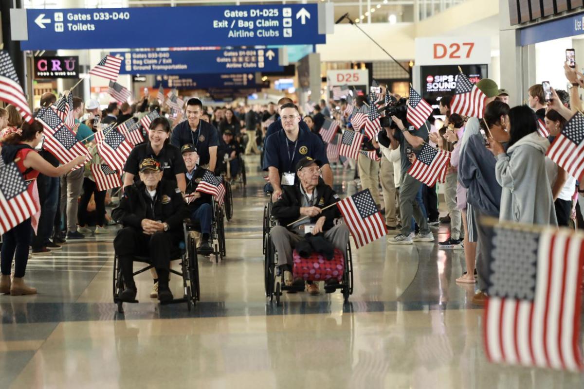 People waving American flags while Veterans come past