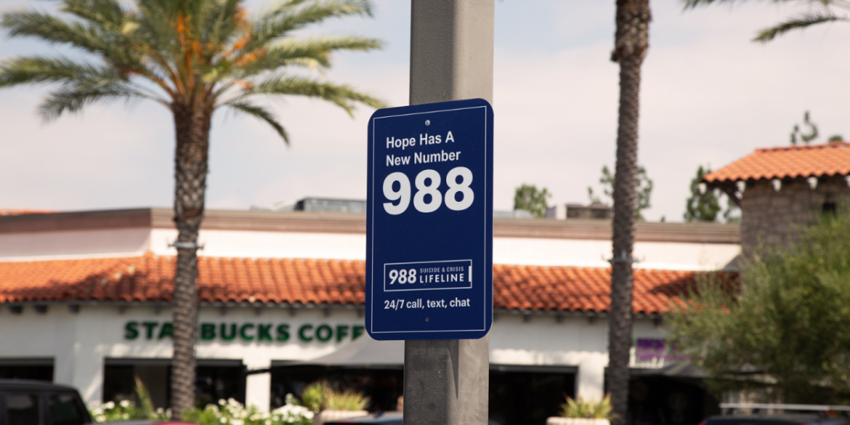 blue 988 sign with palm trees in the background