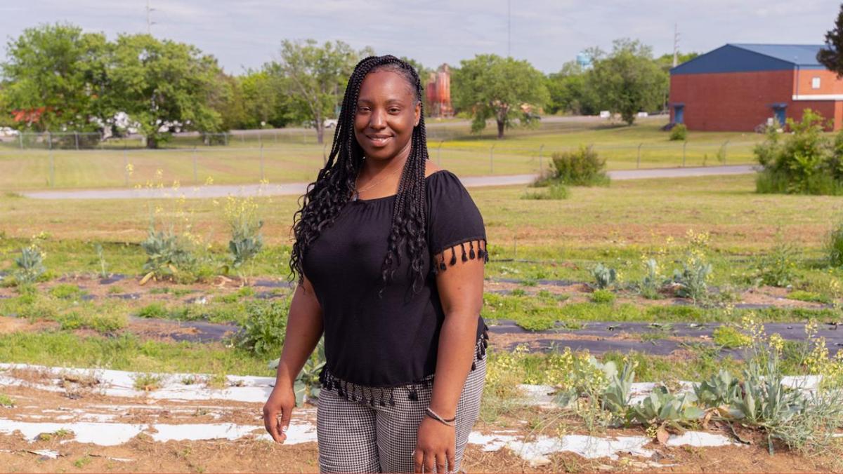 Photo of a person stood in a field looking into the camera