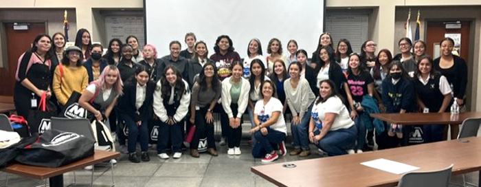 A large group of students and adults in a classroom.