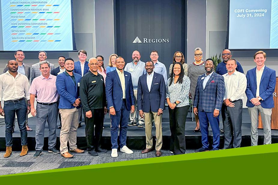 A group posed on a stage area with Regions sign behind them and digital displays to the sides.