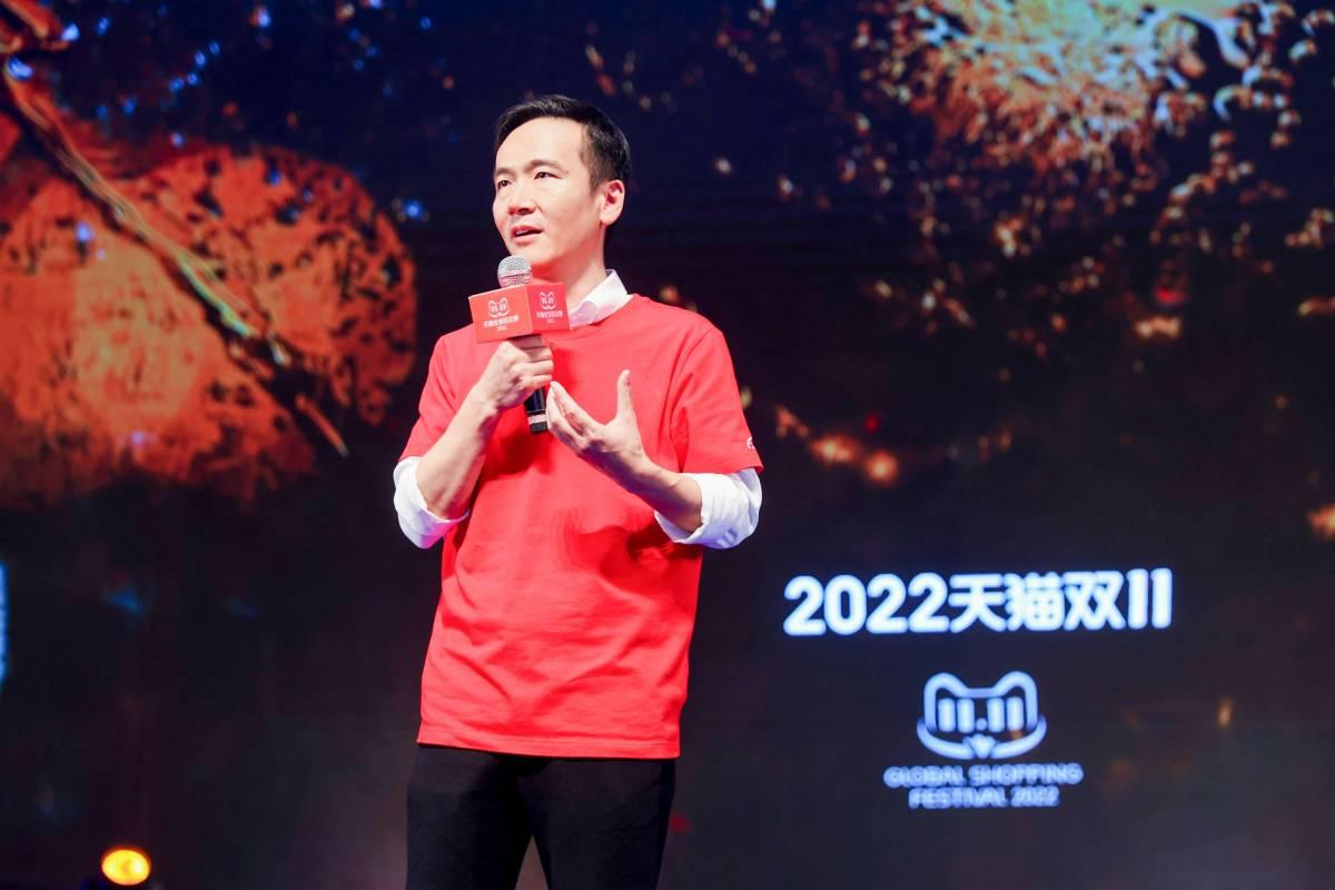 Cheng Li with a microphone, a large screen behind them with "2022" and other writing in a foreign language.