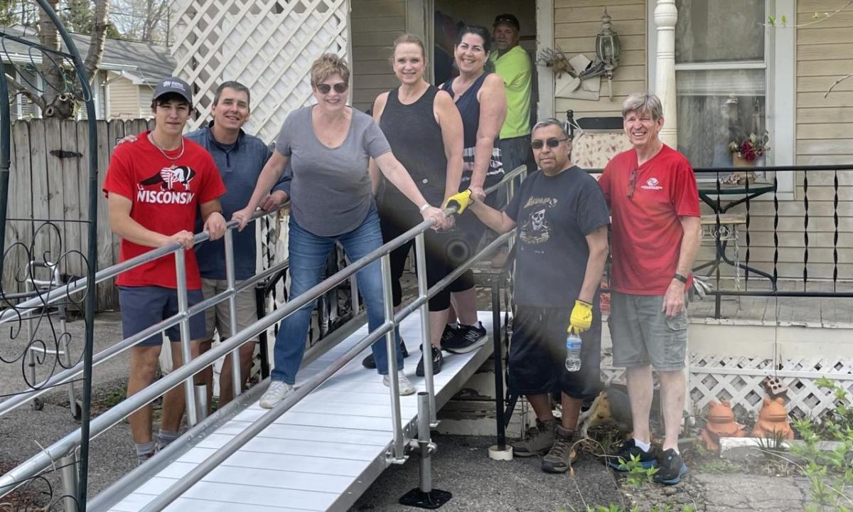 Frank and Shelby shown with Habitat for Humanity volunteers in front of the new ramp at their home.