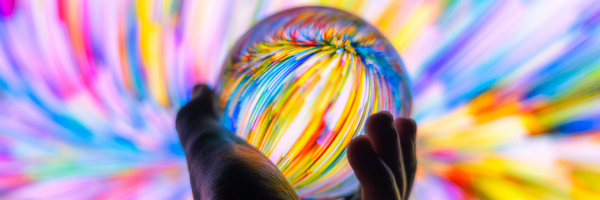 A person holding a colourful glass ball 