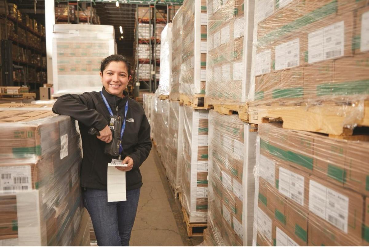 A person leant against pallets in a distribution center 