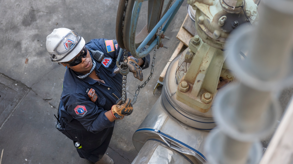 Dynita McCaskill looking up at industrial equipment chain.