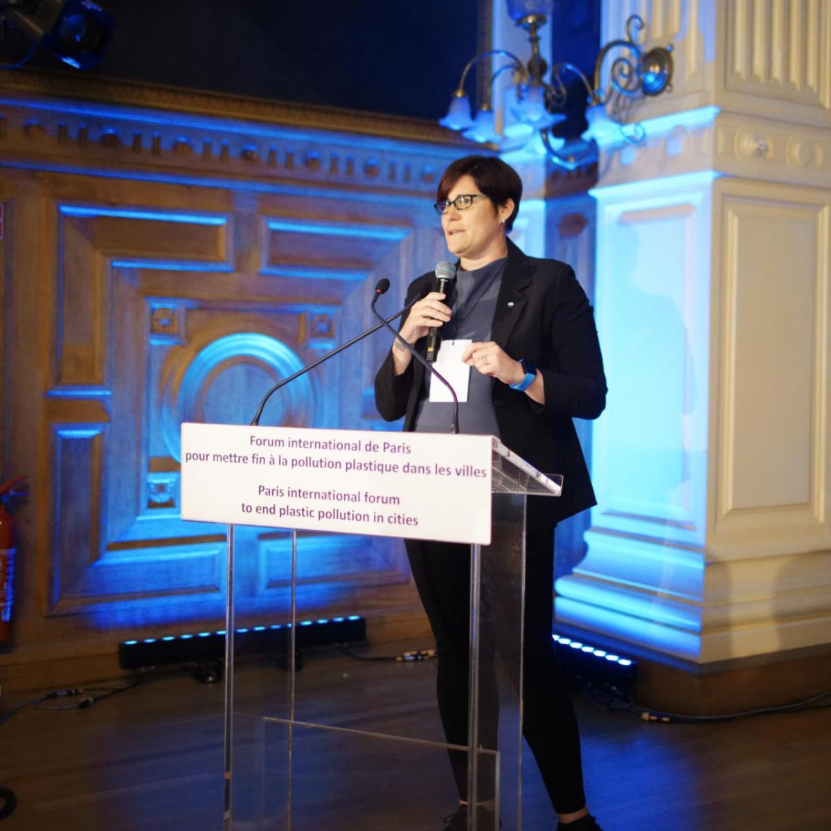 Erin Simon speaks at a lectern on stage