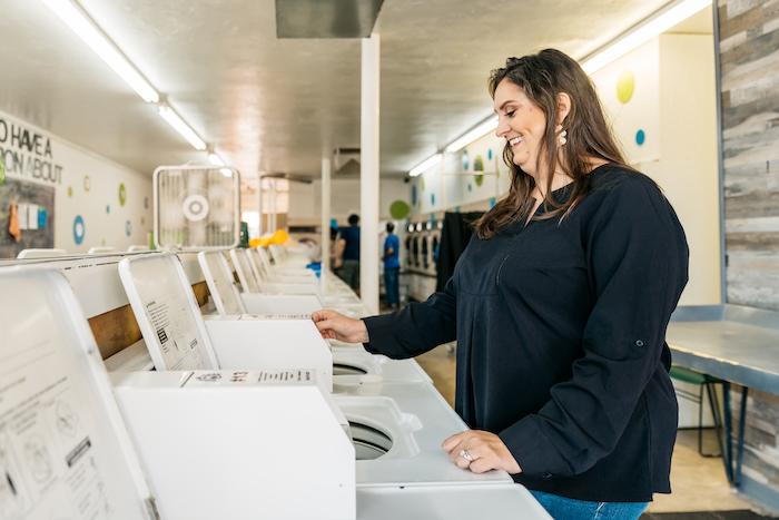 Christy Moore, Social Spin Laundromat AEO in Partnership; standing in a laundromat.