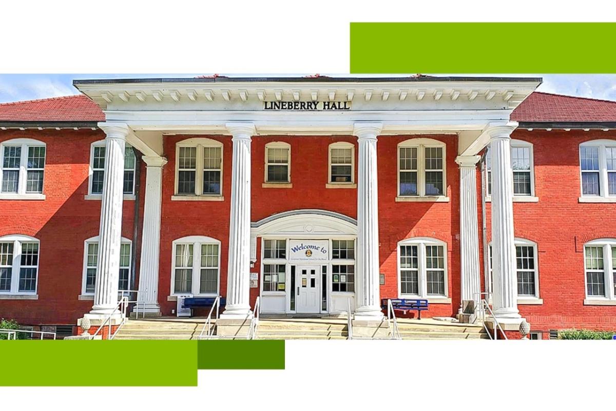 Outside front view of Governor Morehead school, two-story red brick building with white pillars supporting an overhang above the front doors.