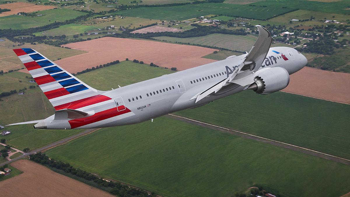 American Airlines plane in flight over fields