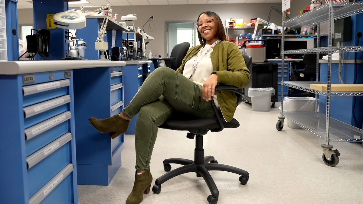 HARMAN Engineer Kelly sitting at her desk.