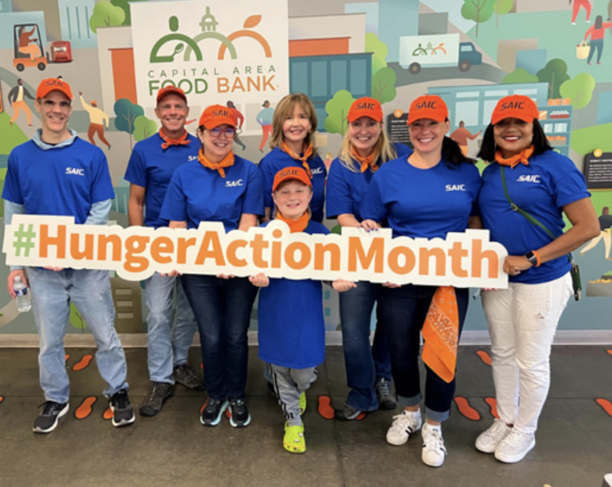 A group of people holding a large Hunger Action Month sign