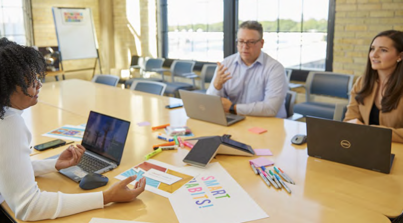 People sat at a table working on laptops