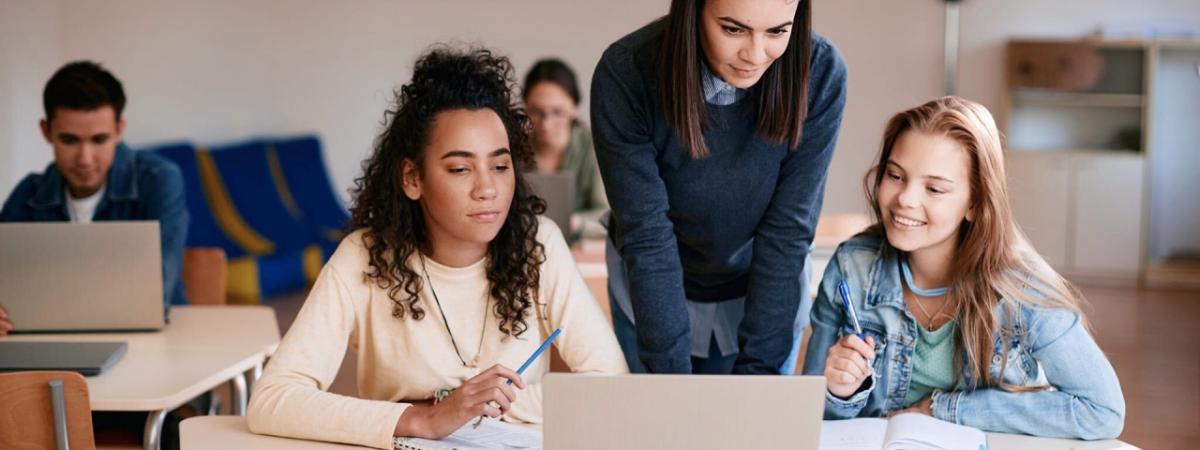 3 women looking at a laptop