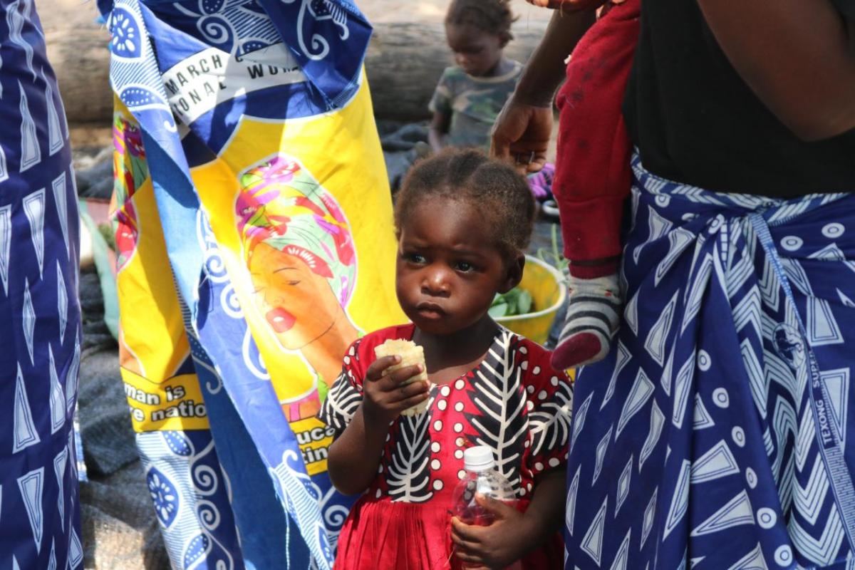 A young girl in the Kaande Camp eats corn. She and her family have little to eat this month.