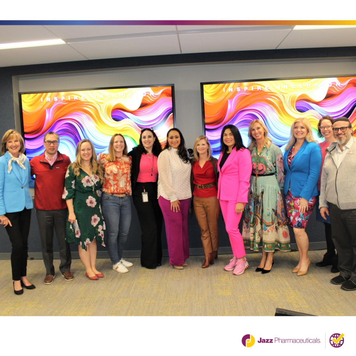 A group of people posed in front of multi-color displays 