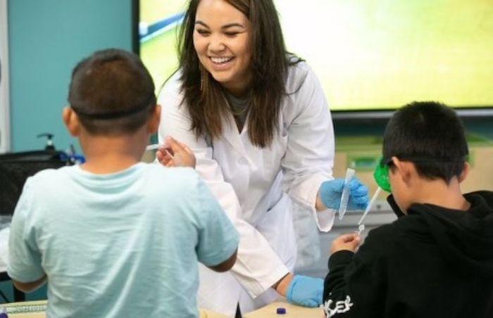 Illumina scientist working with children in a classroom.