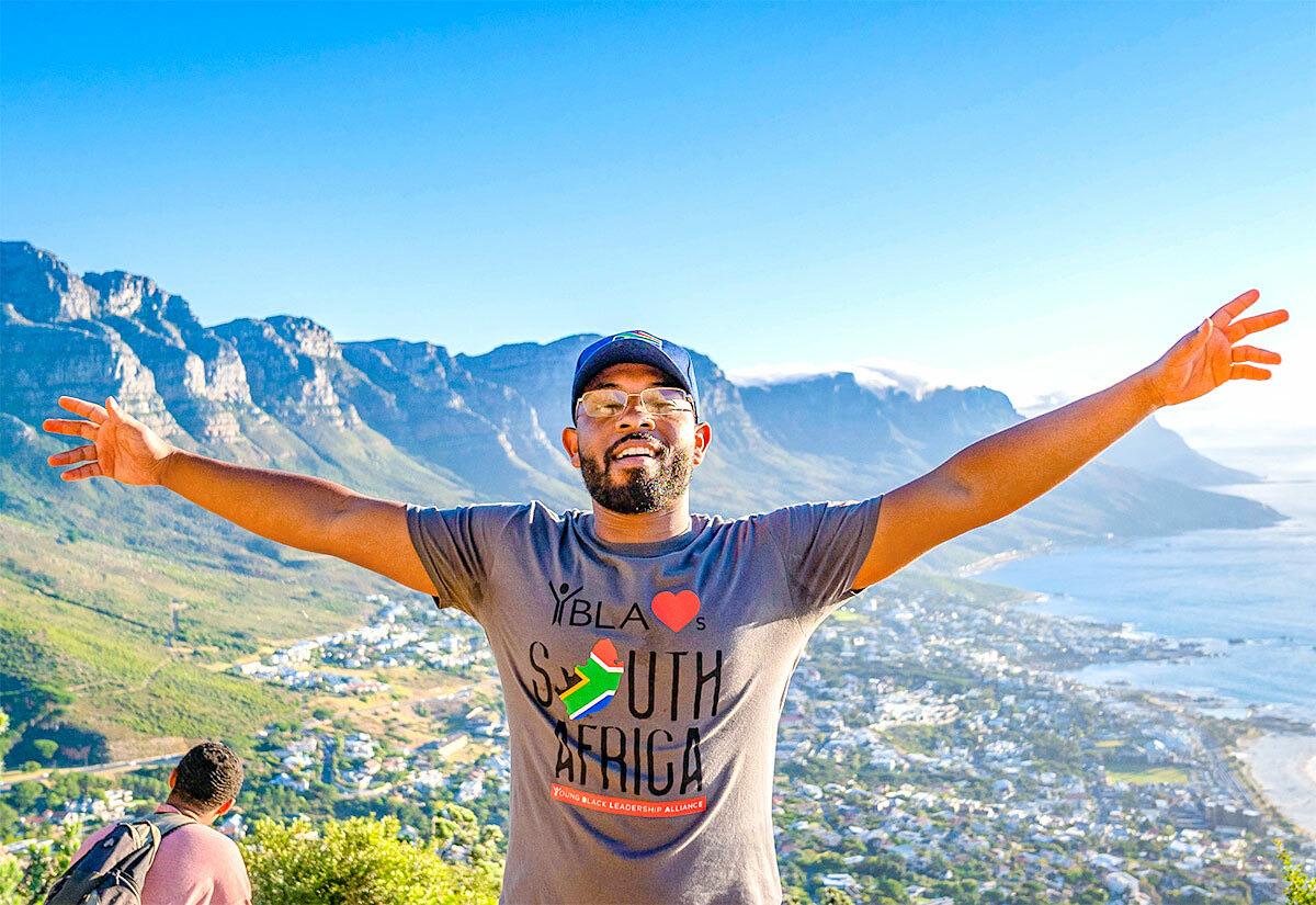 Jalen Roddey stood with his arms out in front of a mountain 