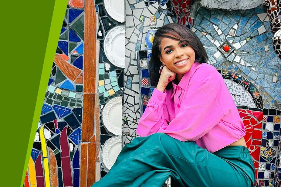 Jordyn Wright posed in front of a mosaic mural.