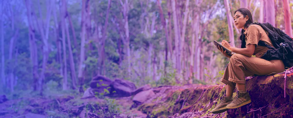 woman writing notes in the forest