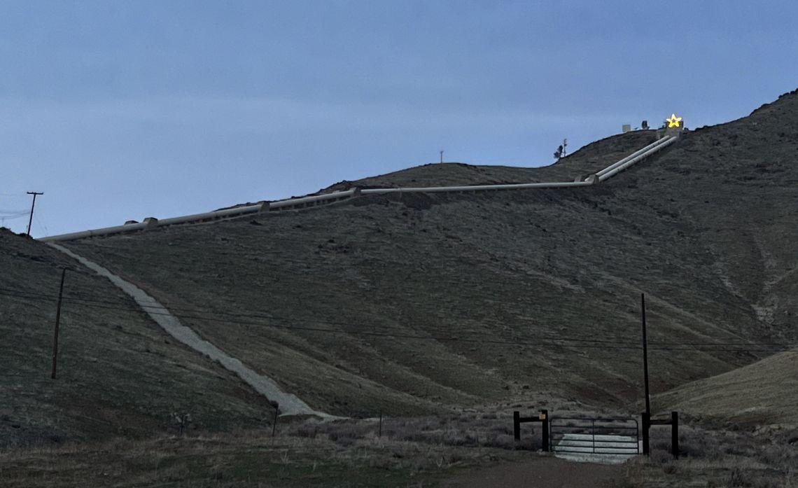 Panoramic view of the valley, a winding road up to a large, brightly lit star.